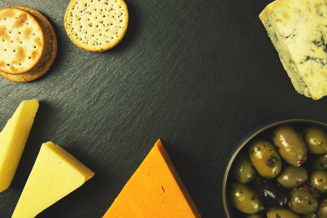 top view of cheese and crackers on a black surface