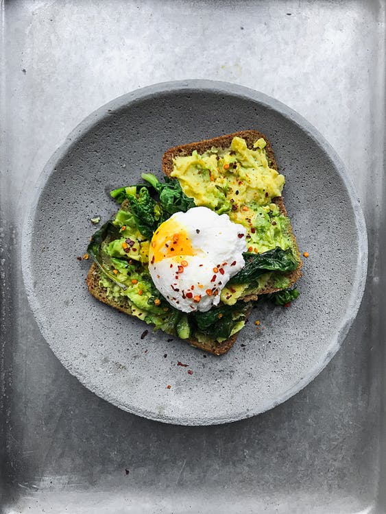 top view of poached egg on top of toast with avocado