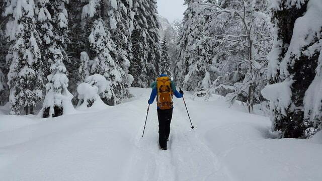 a person hiking through a trail covered in snow