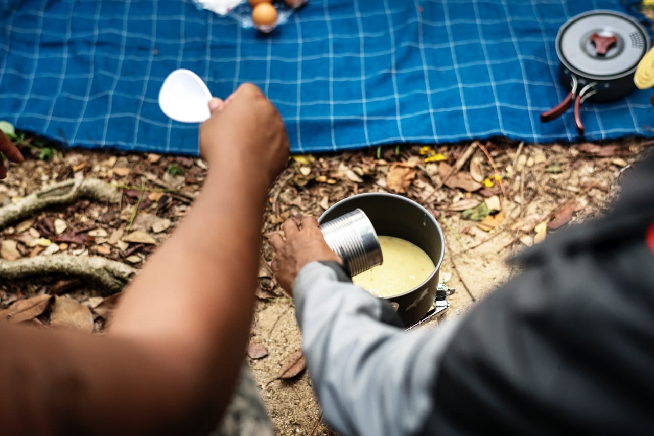 camper pouring soup from a can