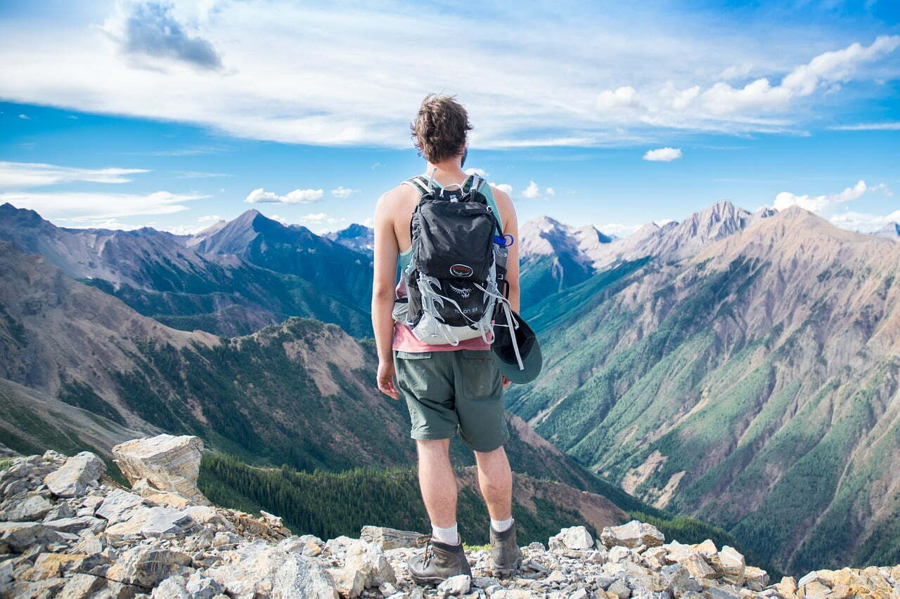 A guy looking on a scenic view of mountains